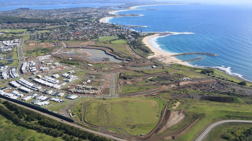 An aerial view of Shell Cove showing the new breakwall and groyne as well as the harbour in the centre, partially flooded after heavy rain.