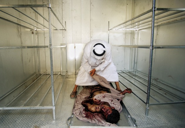 © Lynsey Addario. Abdul Munim Ali Hamood wraps the body of his only son in the Al Karama morgue after he was killed in a car bomb attack in Baghdad, Iraq, June 2004.