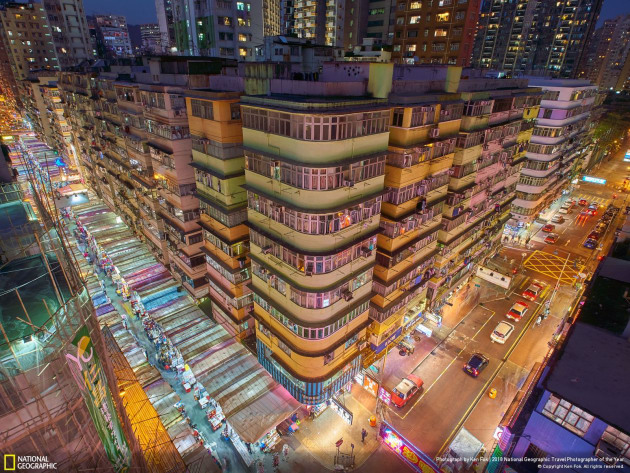 Mong Kok is one of Hong Kong's liveliest districts and includes popular markets, shopping streets, stalls and malls. This photo shot from a roof of an old building. Lights under those tents make it looks more colourful and full of energies.