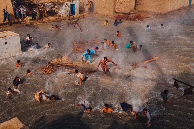 © Daniel Berehulak. Flood victims scramble for food rations as they battle the downwash from a Pakistan Army helicopter during relief operations on September 13, 2010 in the village of Goza in Dadu district in Sindh province, Pakistan. Shot for Getty Images.