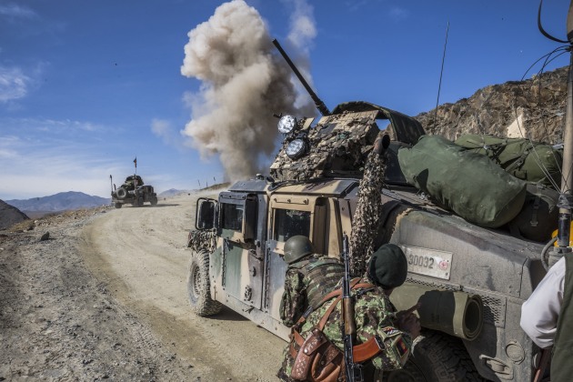 © Daniel Berehulak. Afghan National Army (A.N.A.) soldiers of the 6th Kandak of the 4th Brigade of the 203rd Corps shelter themselves behind a Humvee as the EOD team detonates an Improvised Explosive Device, one of 21 found on the mission. Chak Valley, Wardak Province, Afghanistan. November, 2013. Shot for The New York Times.