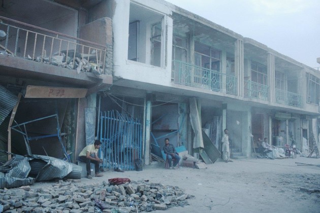 Shopkeepers sit at the entrances to their stores after their doors and windows were blown in by a truck bomb that also killed 15 and injured hundreds of civilians, eastern Kabul, 7 August, 2015. Shot for The New York Times. © Andrew Quilty.