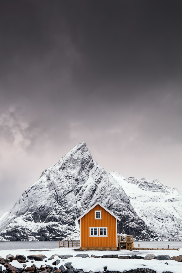 This composition is quite popular amongst photographers at the moment and it's easy to understand why! The beautiful Mount Olstinden has almost the same shape as the roof of this cute yellow cabin and the yellow color creates some amazing contrast to the snow covered mountain.
This place can be found in the Lofoten Archipelago at the small island named Sakrisøy.
I've removed a small cabin in the left side during post process. Beside that, color correction, contrast and sharpness has been done in Lightroom and Photoshop.
Copyright: © Mikkel Beiter, Denmark, Shortlist, Open, Travel (Open competition), 2018 Sony World Photography Awards