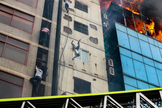 © Mohammad Sazid Hossain. Death of a Fire Victim. A man desperately tries to save himself during a fire that destroyed a 22-storey building in Dhaka. The blaze resulted in 25 deaths and 70 injuries. The man was lowering himself by holding onto a cable, but the heat forced him to suddenly let go and he crashed to the ground.