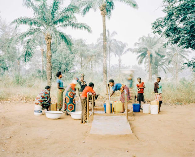 The Water Pump in Osukputu, Benue, Nigeria, 2015. Women and children gather at the hand pump, which serves the entire community of around 800 people with clean, safe water. Daily life in Osukputu has changed dramatically since WaterAid started work in the community to improve access to safe water and sanitation. These vital services have led to healthier families and stronger livelihoods.