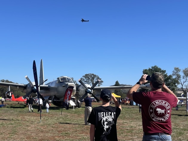 Heritage in motion: a Southern Cross replica flies overhead while a Lockheed Neptune anchors the static display. (Beni McDonald)