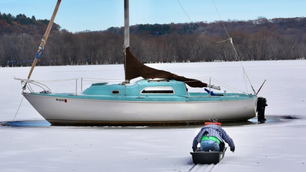 &ldquo;I don&rsquo;t think I can move it now,&rdquo; said Mike Olson, of his 26-foot white-and-blue fiberglass 1977 Pearson sailboat which is frozen in the St. Croix River north of Stillwater. He uses ice picks while he kneels in a sport sled to get to the boat to check for damage Friday, Nov. 15, 2019. (Jean Pieri / Pioneer Press)