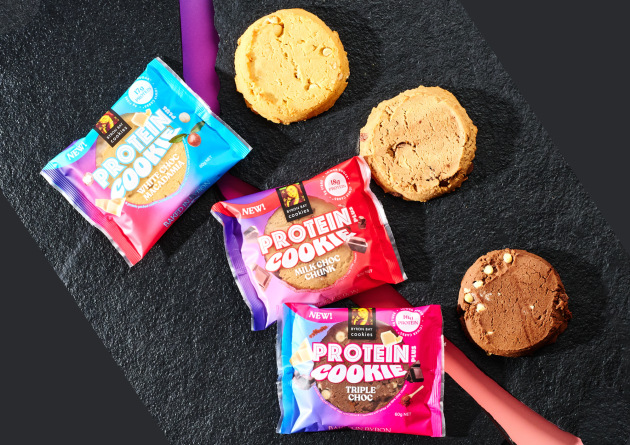 Just in time for its 35th anniversary, the Byron Bay Cookie Company has launched a range of its beloved cookies with a new protein-packed recipe &ndash; initially available in White Choc Macadamia, Milk Choc Chunk, and Triple Choc.
Source: Byron Bay Cookie Co.