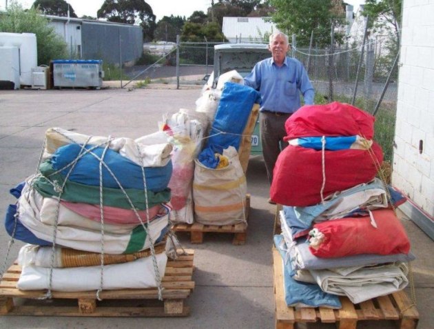 Peter Gately with bails of used sails bound for the Pacific Islands. Photo Sails Ocean Sails.