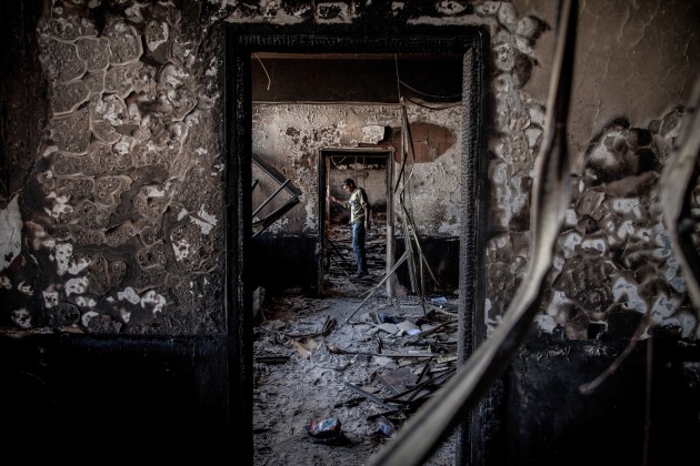 The Libyan Revolution. A man in a government building on the outskirts of Benghazi that had been burned by the opposition, 28 February, 2011. © Nichole Sobecki.