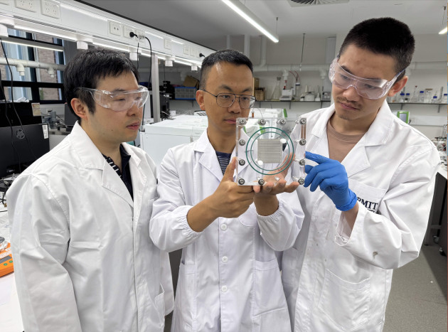 Dr Lei Zhang, Distinguished Professor Tianyi Ma and Dr Peng Li (left to right) in their RMIT University lab, with Professor Ma holding the team&rsquo;s 3 kW carbon conversion prototype device. Credit: Will Wright, RMIT University