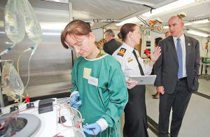 Assistant Minister for Defence, the Honourable Stuart Robert tours a medical facility, and receives a brief on the work being conducted from Commodore Liz Rushbrook. [Photo:Defence]