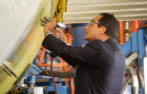 Ambassador Parthasarathi, Consul General of India, drives a rivet into the first of 10 C-17 Globemaster III aircraft being built for India's Ministry of Defence.