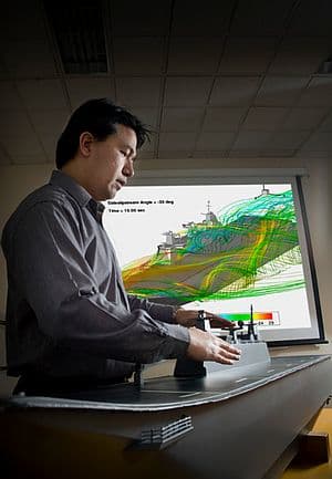 Here a DST Group researcher is working to mitigate risks associated with helicopter operations on the Canberra Class LHDs. By using computational fluid dynamics models, validated by DST Group&rsquo;s low speed wind tunnel using a 1/100 model of the LHD, researchers can gain a detailed understanding of the flow field around the flight deck. Credit: DST Group