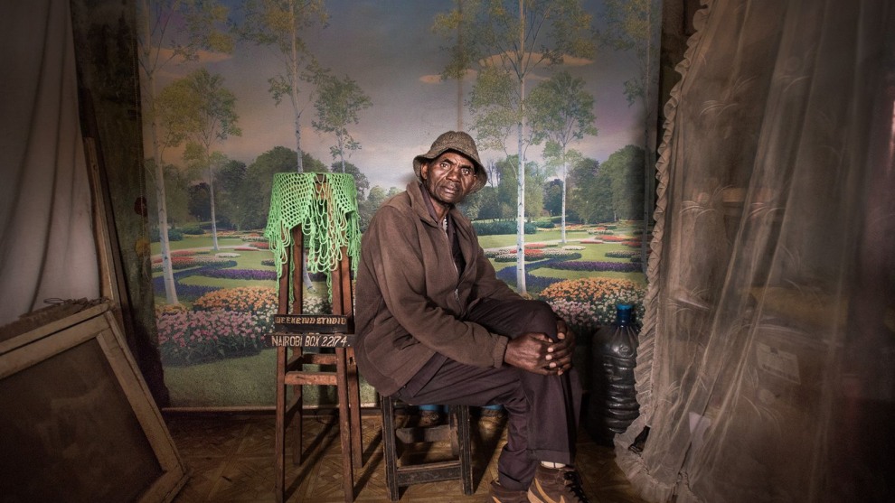 1st Place in People. Photograph and caption by Mia Collis / 2018 National Geographic Photo Contest. I was looking to do a series of portraits showing people wearing their Sunday best when I made this photo of David Muyochokera. It was taken on his last Sunday working as a photographer at Weekend Studio, in Kibera—a large shantytown in Nairobi, Kenya.

My friend Peter, a local resident, had pointed me to the photo studio just as I was about to leave the area. It was a stunning space, with whimsical backdrops and natural light coming through the doorway. David had worked there for 37 years, but Weekend Studio was about to close permanently. Phone cameras were so common now, he said, and fewer people wanted studio portraits. David planned to retire and return home to the countryside. I was troubled by the studio’s imminent closure, so I eventually took over the rent. A portrait of David now hangs at Weekend Studio in his memory.