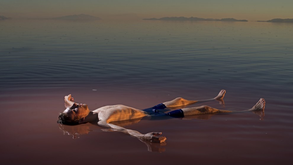 Carolyn Drake
Magnum Photos

Great Salt Lake, Utah. USA. 2016.

“I made this picture in 2016, on the north arm of the Great Salt Lake in Utah. This part of the lake stopped receiving fresh water over 50 years ago, when the Southern Pacific Railroad built a causeway that split it in two and made the upper half incredibly saline, a haven for a red-algae called Dunaliella salina. A couple months after I was there, a bridge was constructed that allowed the water in the upper portion of the lake to start mixing with the fresher water in the lower lake, where another species of algae tints the water green.

It is a picture of man in nature that feels strikingly unnatural; the natural order is askew. Humans will force the two species of algae to meet, coexist, fight for dominance, evolve, die off.”