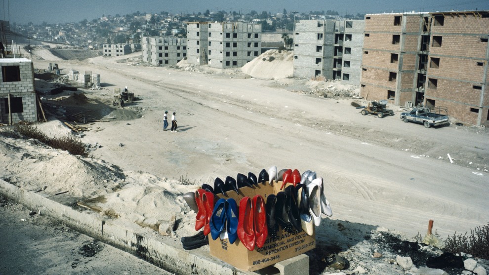 Alex Webb
Magnum Photos Tijuana, Mexico. 1995.
“I’ve long been fascinated by the transience and paradoxes
of the U.S.-Mexico border. Between 1975 and 2001, I crossed the border numerous times, photographing  this unique  region to try to make sense of it. Even though these two countries  were culturally worlds apart, it sometimes seemed that the border region was a kind of third country between them – 2,000 miles long and 10  miles wide, a place where two countries meet, sometimes easily, sometimes roughly, and often with
a confounding note of surrealism. Looking back, I realize that Crossings (2003), the book I made from this work, reflects the last days of a more porous border between the United States and Mexico, so different from today’s militarized border.

In 1995, while walking through the outskirts of Tijuana,
I was surprised to find this box of brightly colored shoes,   which seemed so out of place on this dusty, isolated embankment.