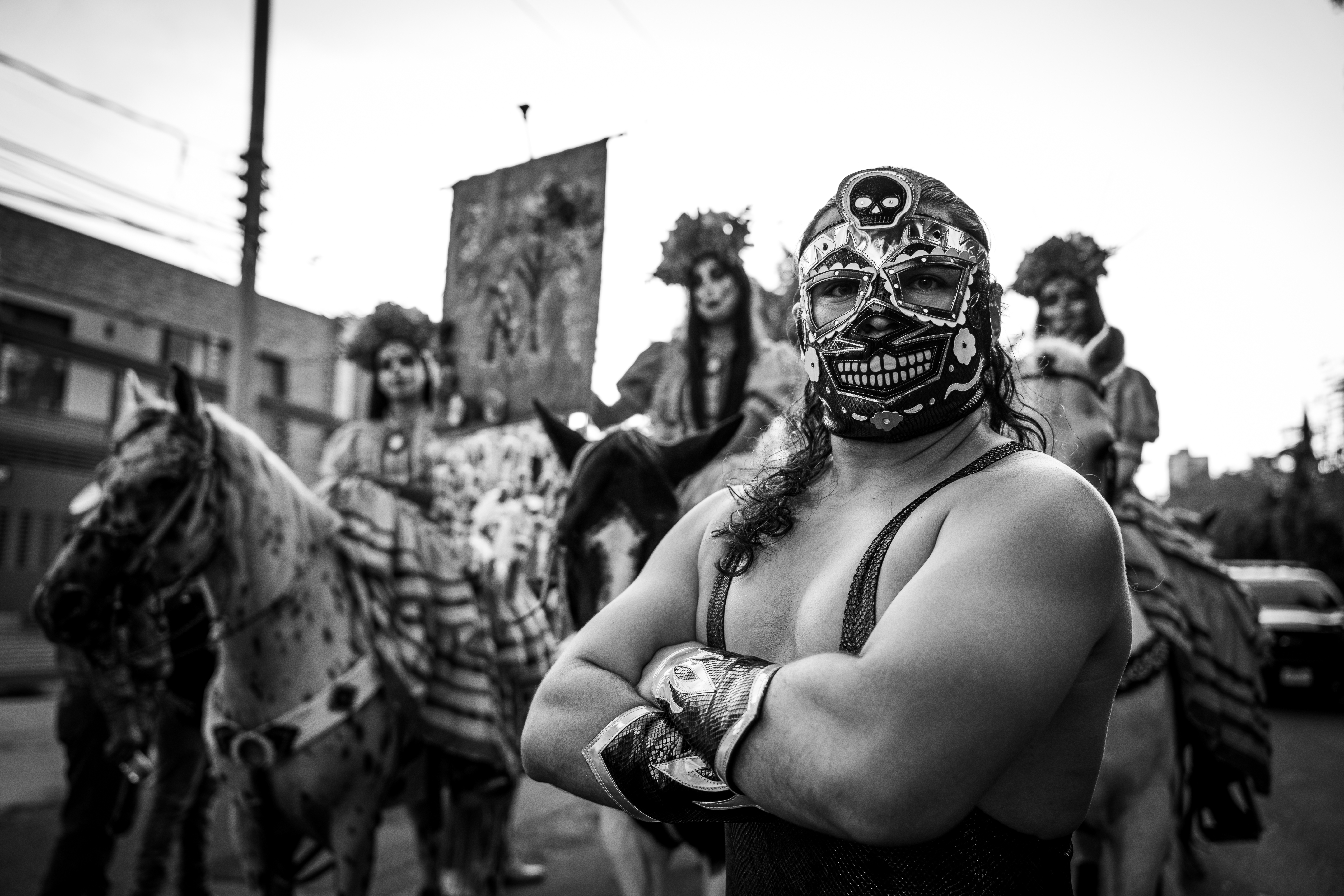 Shot during one of Guadalajara’s Day of the Dead parades, this image frames a horseback Catrina between two luchadores. To take this image, I hailed down a bus of luchadores and politely requested to photograph them. I was initially denied but, endeared by my earnest request in Spanish, two of the Mexican wrestlers stopped the bus and decided to strike some fantastic poses. At that point, the Catrinas, whom I had previously photographed, approached and joined the composition in the background. Sony A7C II, Sigma 24-70 f/2.8 G2 lens @ 24mm. 1/100s @ f/8, ISO 100.