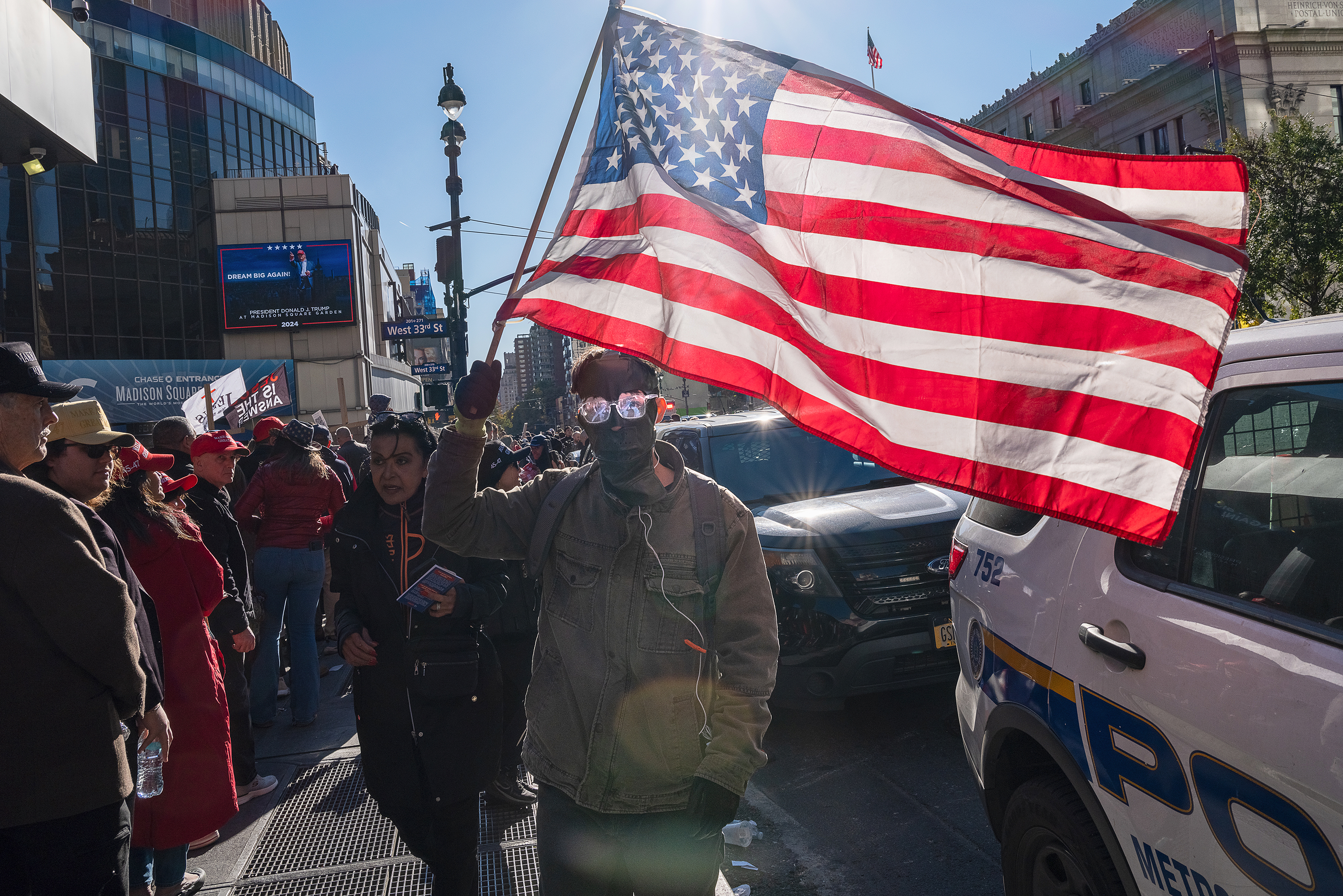 Madison Square Garden, Trump Rally.Outside Madison Square Garden, Donald Trump’s campaign rally drew supporters who queued around the block until the venue hit capacity. Police formed a barrier between them and a sea of protestors voicing their opposition. As the afternoon stretched on, tension escalated.