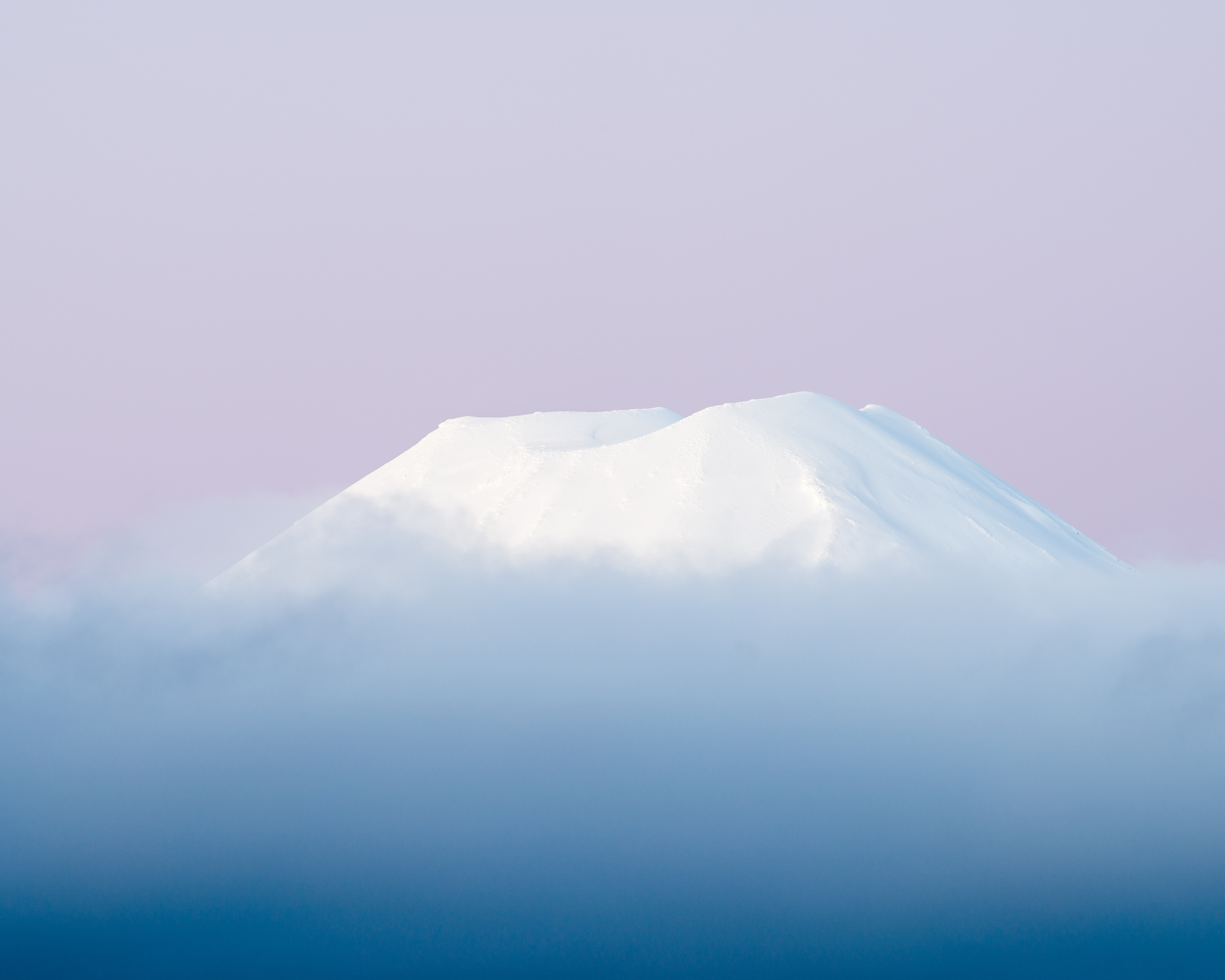 Mount Ngauruhoe, Tongariro National Park, New Zealand. The peak rises above a sea of cloud, isolating it from its base and giving it the appearance of floating within the sky, framed by the soft pastel tones of sunrise. Nikon D800E, Nikkor 70–300mm lens @ 300mm. 0.4s @ f11, ISO 100.