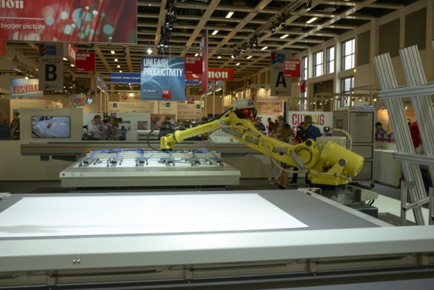 This robot on the Canon stand loads media to the Arizona flatbed, and then unloads it to the cutting table.