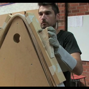 Bending steamed veneer sections over a former.