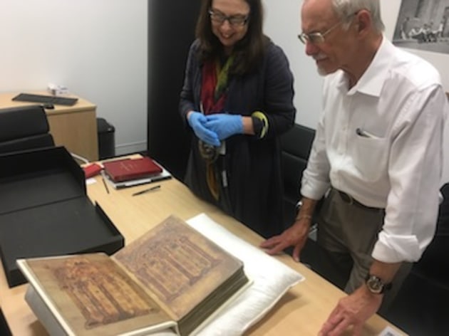 Curator Anni Turnbull shows James Cryer a specimen from the State Library rare book collection.
