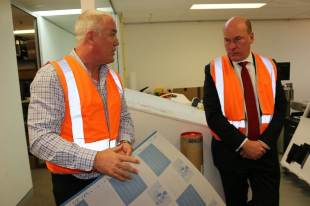 Adam Hanks (left) shows Trent Zimmerman an offset printing plate.