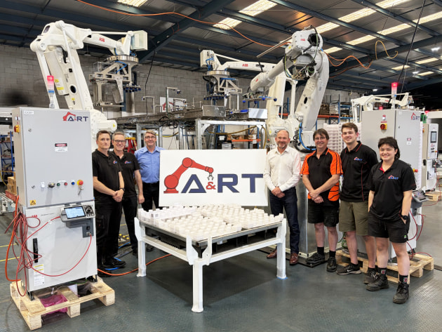 Dale Collinson and Phil Biggs with members of the A&RT team pictured before a recently completed four-robot palletising and depalletising solution