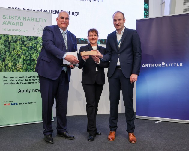 Dr. Steffen Rohlmann (right), Development Basecoat EMEA, and Sonja Glanemann (center), Global Sustainability Manager, Automotive OEM Coatings, receive the Sustainability Award in Automotive 2026 &ndash; Technology: Operations & Supply Chain &ndash; for the Overspray Free Application (OFLA) process from Prof. Dr. Uwe Dieter Grebe from TU Wien &ndash; Vienna University of Technology, at the award ceremony in Frankfurt.