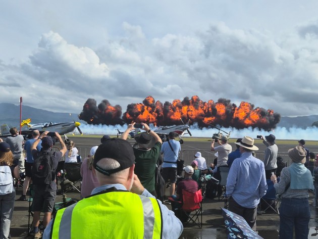 crowds reach for their phones as the Paul Bennet Airshows pyrotechnics display lights up the sky (Beni McDonald)