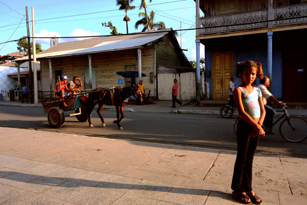 Niquero is a small town in southeast Cuba, a place I used to know well, and one of my favourite places to shoot Cuban life. This was really early in my digital transition era, and was shot on a basic Canon Rebel. It was sunset, and there was so much character on the streets. I was shooting the various bikes and horses here when this young girl walked past and just stood in the middle of my shot, politely bemused at the sight of a gringo with a camera. I spoke and smiled at her, and she didn't blink an eye, so she became part of the scene. Canon EOS Rebel XT. 17mm. 1/80s @ f8, ISO 100.