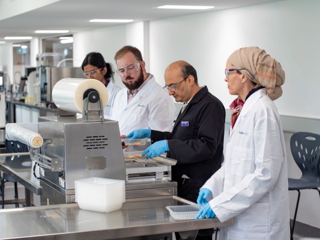 L-R: Geethi Eshani Ilukpitiya, Justin Nugent, Dr Bhaskar Adhikari, Charlotte Duniam utilising the flexible design of the FaBA MakerSpace to create a production line for the packaging of products.